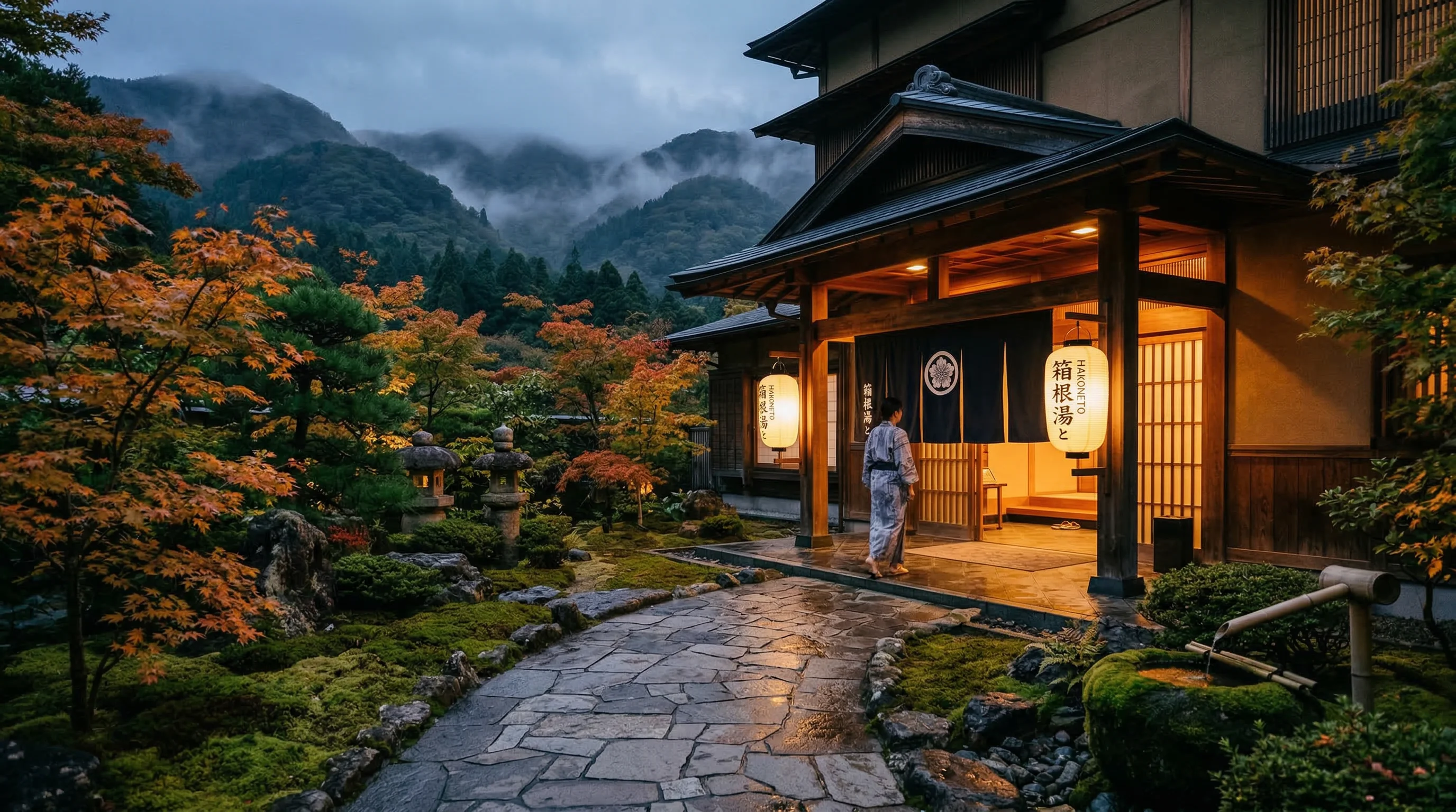 Traditional Japanese ryokan entrance at dusk with lanterns illuminating a stone garden path in Hakone